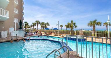 Resort-style pool w/ lounge chairs, palm trees & a relaxed spot to cool off under the sun.