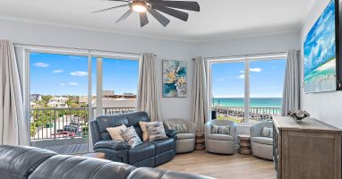 Living room with sectional, smart TV, and balcony access