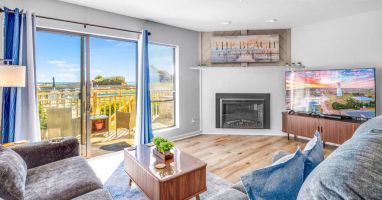 Beautiful living room: big TV, electric fireplace, deck views, USB/C plugs, queen pullout sofa.
