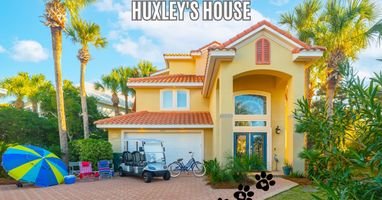 Welcoming front exterior surrounded by palms and vibrant landscaping