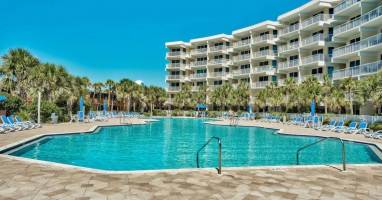 Resort-style pool surrounded by palm trees, perfect for cooling off after a sunny beach day.