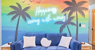 Happiness Comes in Waves — our signature mural sets the tone for the whole trip. You can't be stressed in this room.