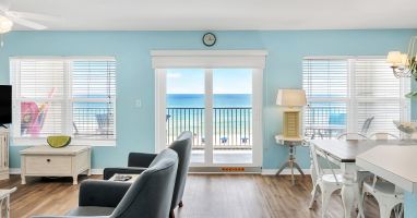 Panoramic view of living, dining, and kitchen area showing balcony beach view.