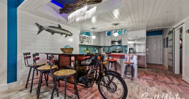 Unique driftwood chandelier with LED lighting above motorcycle dining table 