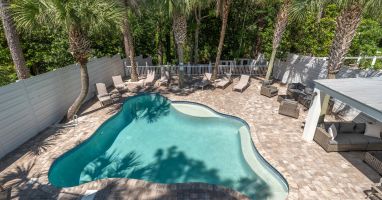 A large pool and expansive patio with room to lounge and covered seating.