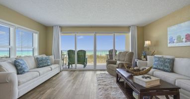 Step into the spacious living room of Cabana Club 101, where queen sleeper sofas and a smart TV face expansive sliding doors showcasing breathtaking Gulf views. Perfect for sunset watching or relaxing after a day on the sugar white sand.