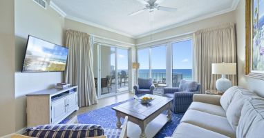Elegant beachfront living space with floor-to-ceiling windows overlooking the Gulf. Welcome to Crescent 411