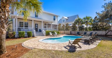 Beautiful coastal home with private pool surrounded by swaying palms and comfortable loungers for the perfect Florida getaway.