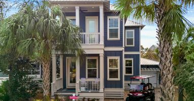 Charming coastal retreat with tropical palm trees and convenient golf cart parking for easy beach town exploration.