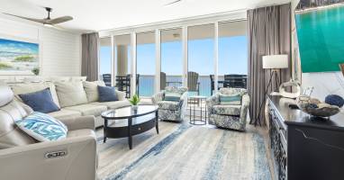 Sink into plush seating while soaking up breathtaking ocean views from your private balcony in this bright, airy living space.