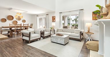Relax in your bright, open living space featuring cozy tufted seating and natural textures that create the perfect atmosphere for unwinding.