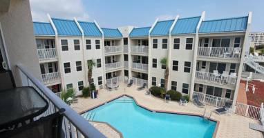 Your balcony view overlooking a sparkling courtyard pool—your perfect spot for morning coffee or sunset unwinding.