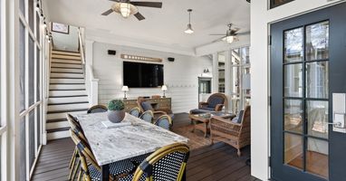 Your elegant screened porch offers the perfect blend of comfort and coastal charm with ceiling fans, dining space, and cozy seating.