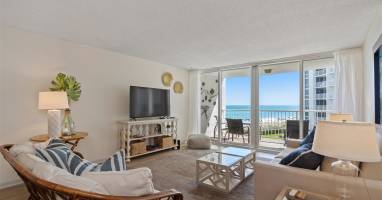 Relax in your coastal living room with stunning ocean views from the private balcony. Comfortable seating and beach-inspired decor create your perfect seaside retreat.