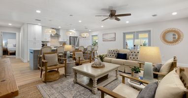 Relax in your spacious open-plan living area with coastal-inspired decor, modern kitchen, and comfortable seating perfect for gathering with loved ones.