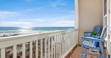 Wake up to endless gulf views from your private balcony, where blue Adirondack chairs invite morning coffee moments and sunset relaxation.
