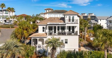 Stunning Mediterranean-style beachside villa surrounded by lush palms in an upscale coastal neighborhood.