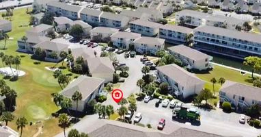 Aerial view of the vacation rental property nestled within a well-maintained residential community with landscaped grounds and convenient parking.