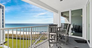 Your private balcony offers stunning oceanfront views while you relax in comfortable seating, watching beach life unfold below.
