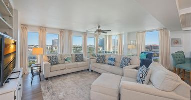 Unwind in your spacious living room with panoramic city views through floor-to-ceiling windows and comfortable seating for the whole group.