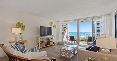 Relax in your coastal living room with stunning ocean views from the private balcony. Comfortable seating and beach-inspired decor create your perfect seaside retreat.
