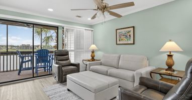 Unwind in your spacious living area with comfortable leather seating, tropical breezes from your private balcony, and soothing coastal views to enhance your relaxation.