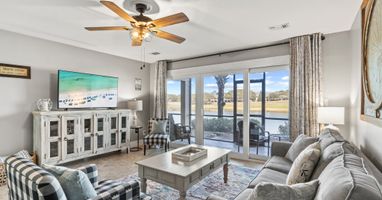 Bright, beautifully furnished living area with scenic lake views and direct patio access—perfect for relaxing coastal mornings and sunsets.