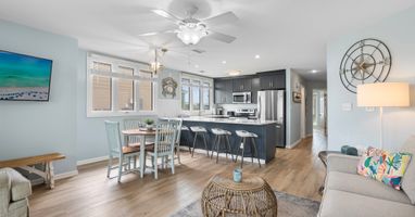 Spacious open layout with coastal charm, featuring a full kitchen, bar seating, dining table for four, and a cozy living area—perfect for relaxing and entertaining by the lake.