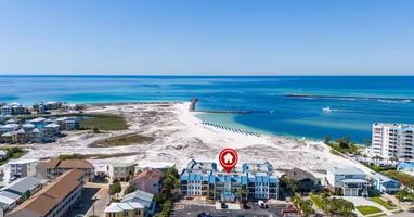 Aerial view showcasing the property's prime beachfront location on Florida's stunning emerald coast, with pristine white sand beaches and turquoise Gulf waters just steps away.