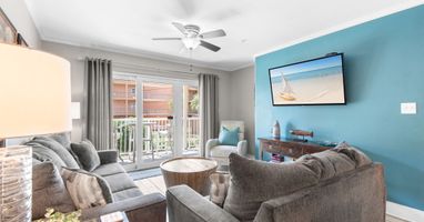 Unwind in your bright living room with plush seating, breezy ceiling fan, and coastal touches that set the tone for your beach getaway.