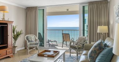 Unwind in your oceanfront living room where turquoise waters stretch endlessly beyond your private balcony and coastal breezes drift through elegant furnishings.