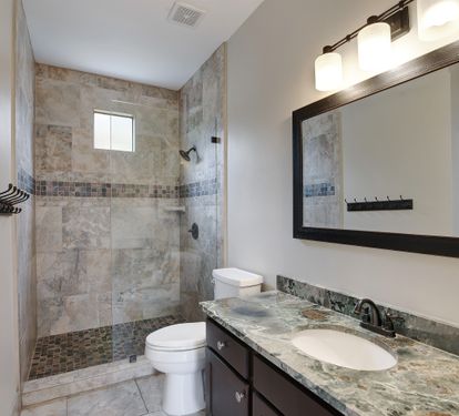 Main-level bathroom with walk-in shower and granite vanity