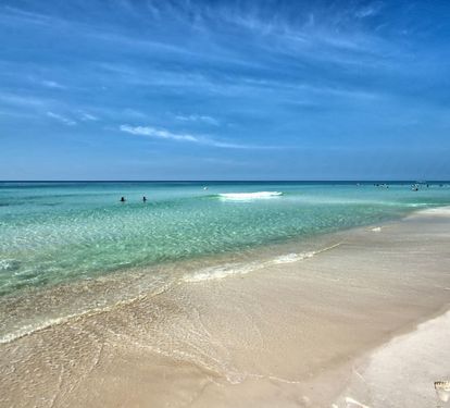 Calm shoreline w/ clear water & soft waves, perfect for long beach days