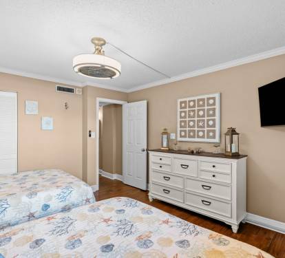 Guest bedroom with two full beds, smart TV and clothing storage