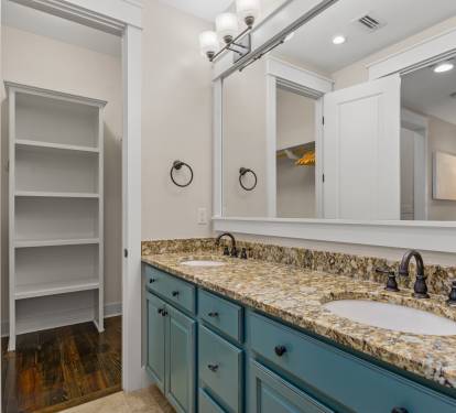 Vanity & storage view w/ granite countertop, generous cabinetry & nearby closet space.