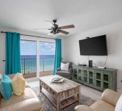 Living Room with Breathtaking Views Relax in this stylish living area, featuring plush seating, coastal decor, and a large flat-screen TV. The sliding glass doors lead to your private balcony, showcasing uninterrupted views of the sparkling Gulf waters. P