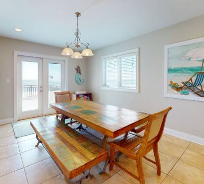 Dining area with doors to beach facing deck