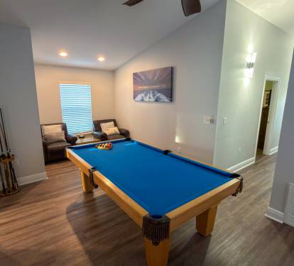 This upstairs lounge combines classic game-room fun with a cozy seating nook, ideal for watching the action or taking a quiet break.