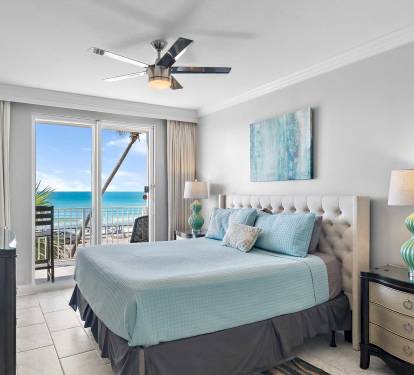 King primary suite with balcony access and ocean views