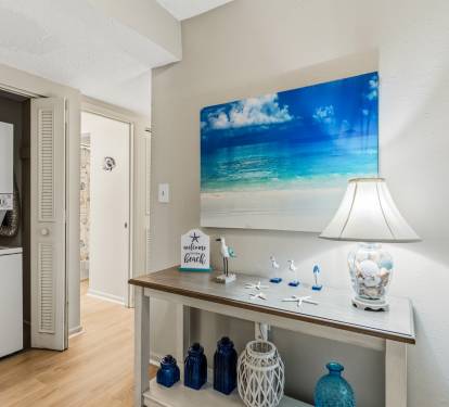 Beachy entry table w/ coastal decor sets a warm welcome as you arrive.