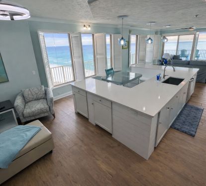 Newly renovated large open kitchen has a u-shaped island w large farmhouse sink
