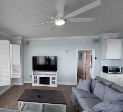 New living room furniture &amp; 65" TV on fireplace overlooking the Gulf