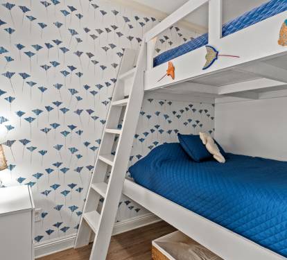 The kids' room they'll tell all their friends about. Queen-over-queen bunks with whimsical fish wallpaper built for cousins sharing a room.