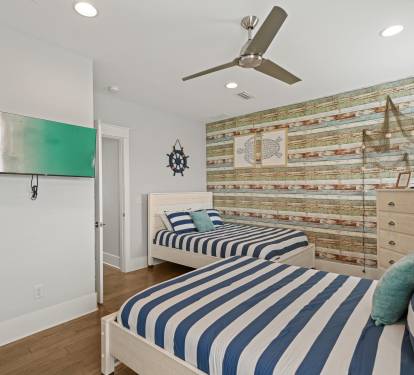 Double Queen Suite with wall-mounted TV and ample space for guests.