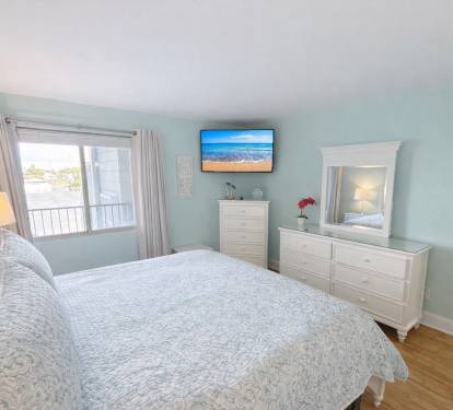 Spacious primary bedroom with KING BED and soft coastal tones and decor. 
