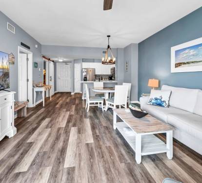 Open living & dining area w/ coastal decor, comfy seating, & space to relax together