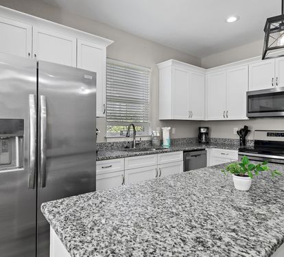 The kitchen is equipped with a large two-door refrigerator with ice maker, stove, oven, coffee-maker and dishwasher.