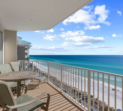 Balcony setup w/ seating & sweeping ocean views just beyond the railing.