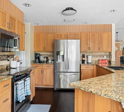 Spacious modern kitchen with granite countertops and stainless steel appliances.