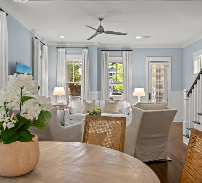Open living & dining space w/ soft blue tones, comfy seating & tall windows that keep the room bright and inviting.